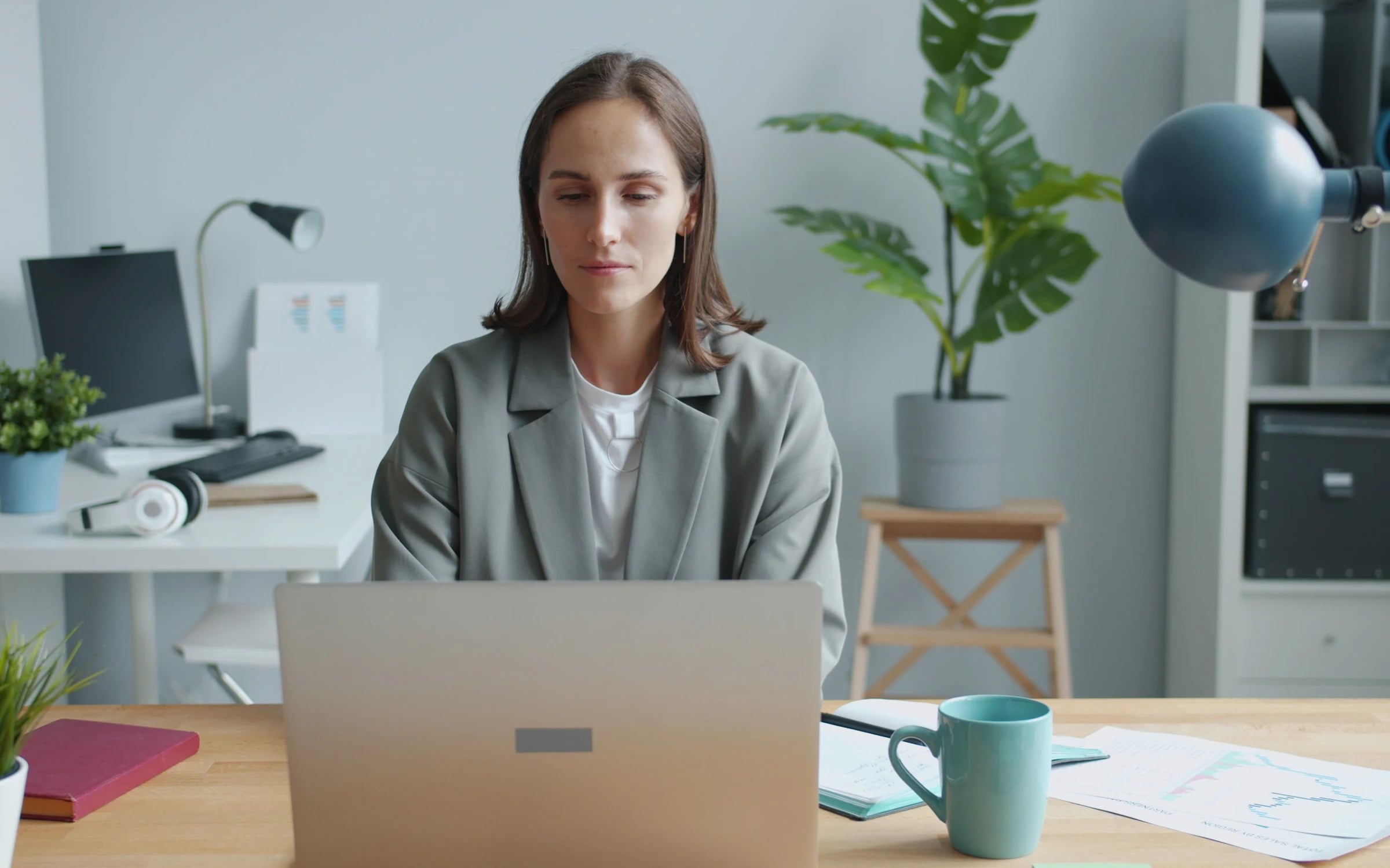 A person working on a laptop at a desk in a bright office