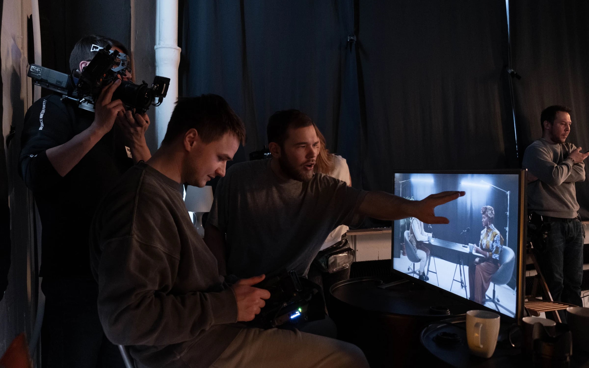 A video production crew reviewing a shot on a studio monitor